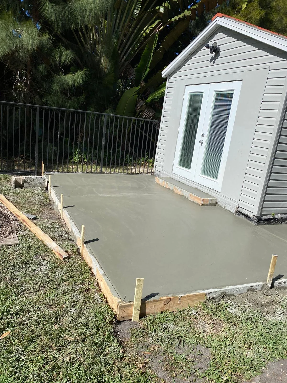 Fresh concrete patio at a double-door entrance